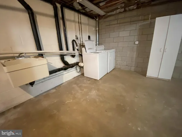 a view of walk in closet with clothes and white door