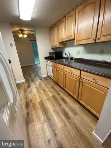 a kitchen with granite countertop a refrigerator a sink and dishwasher