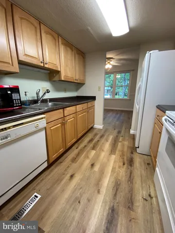 a kitchen with granite countertop a sink stainless steel appliances and cabinets