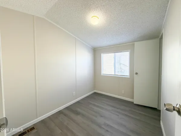 an empty room with wooden floor and closet