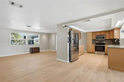 a view of a kitchen with a sink refrigerator and windows