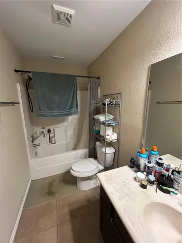 a bedroom with a bed and a flat tv screen on dresser