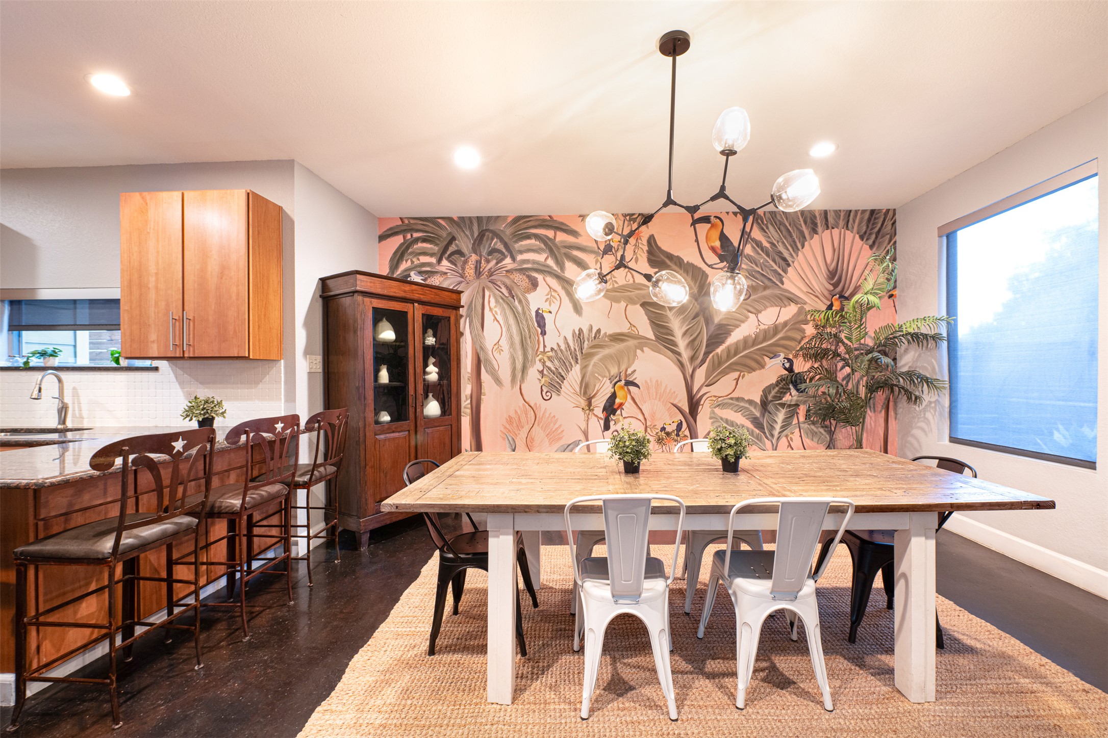 2302 East 9th Street Austin, TX 78702 - Photo 1 of 31 Bold tropical wallpaper enlivens this dining area, complete with a modern chandelier and kitchen island seating.