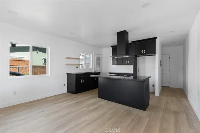a kitchen with granite countertop a refrigerator cabinets and wooden floor