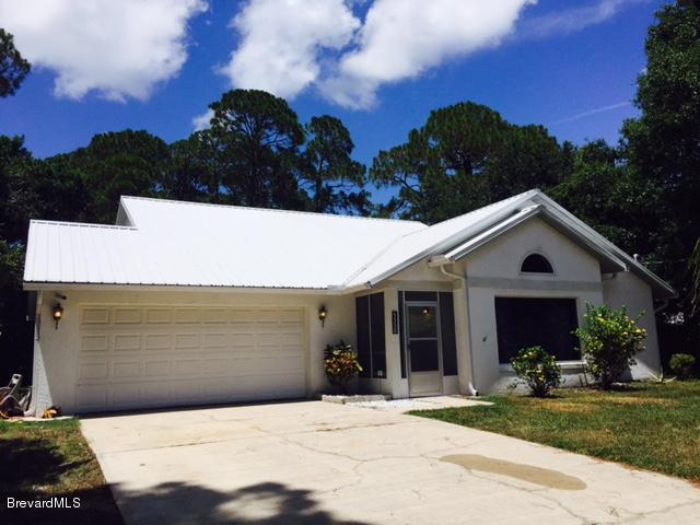 5330 Holden Road Cocoa, FL 32927 - Photo 1 of 23 a view of a white house with a yard plants and large tree