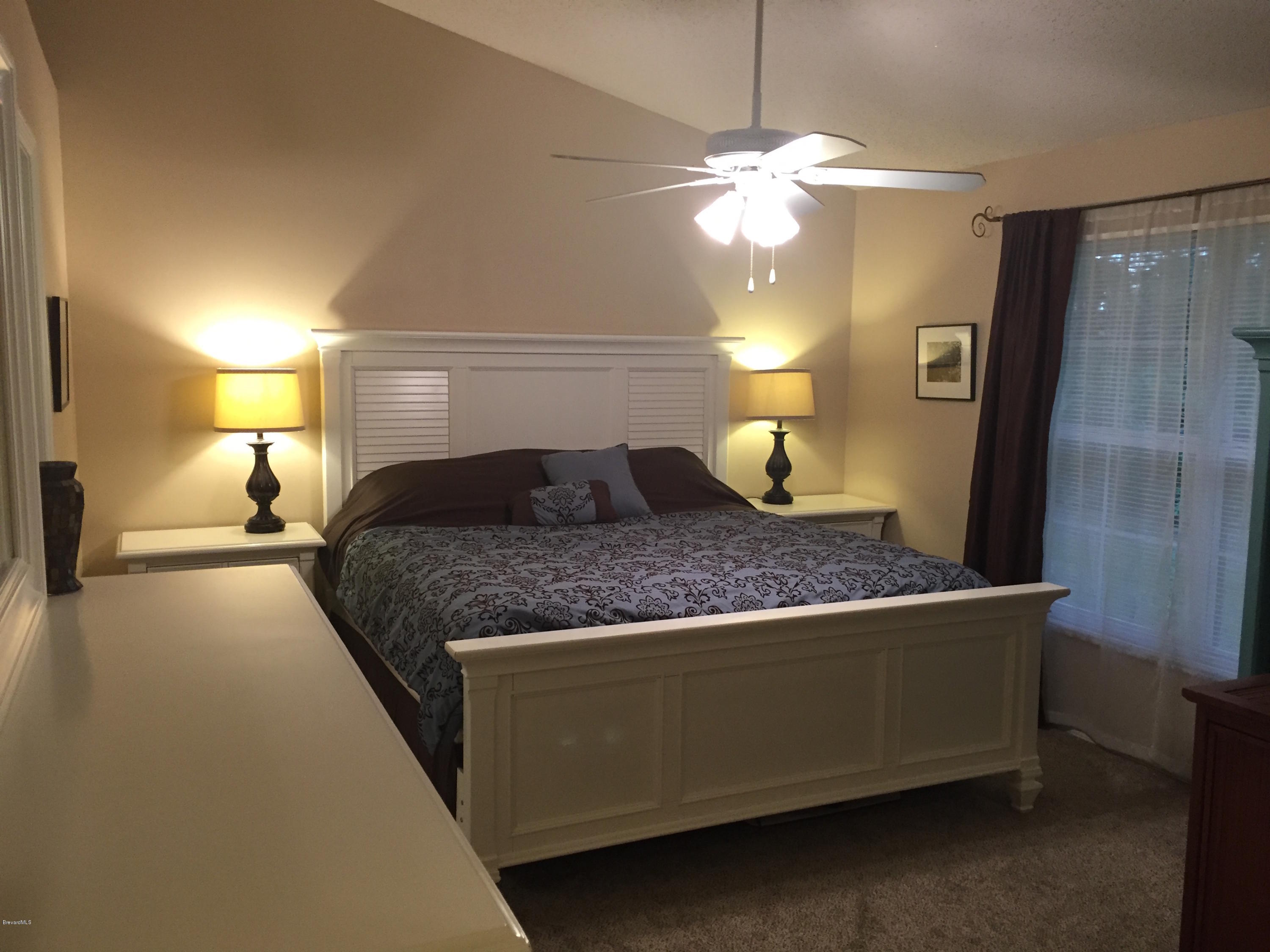 5330 Holden Road Cocoa, FL 32927 - Photo 12 of 23 a bedroom with a bed and a chandelier