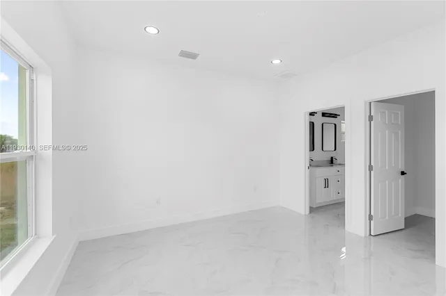 an empty room with a cabinet and mirrors