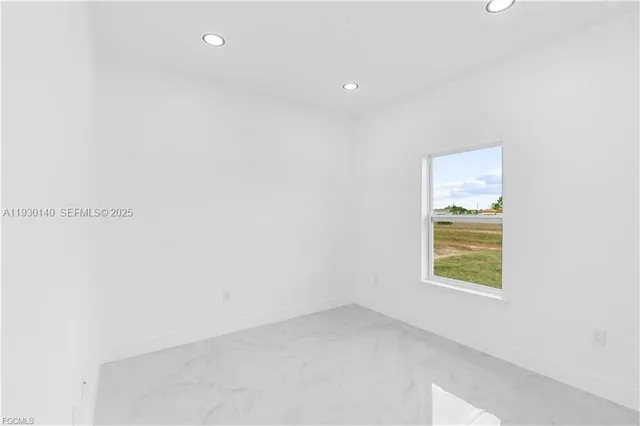 a large kitchen with stainless steel appliances a large counter top a refrigerator and a stove