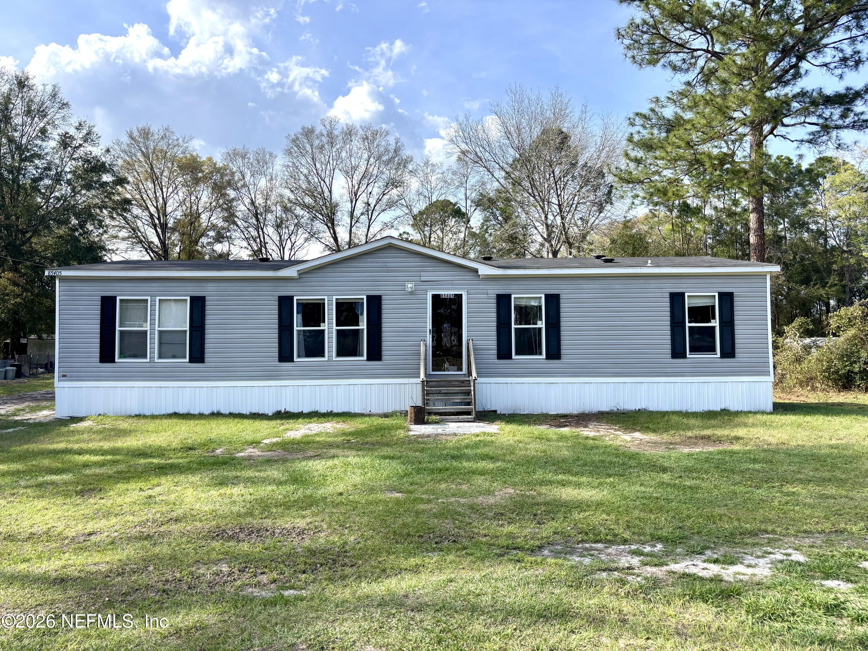 a front view of a house with yard and green space