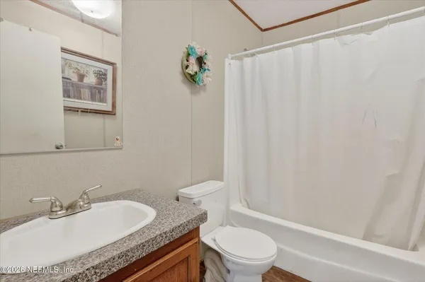 a bathroom with a granite countertop sink toilet and a mirror