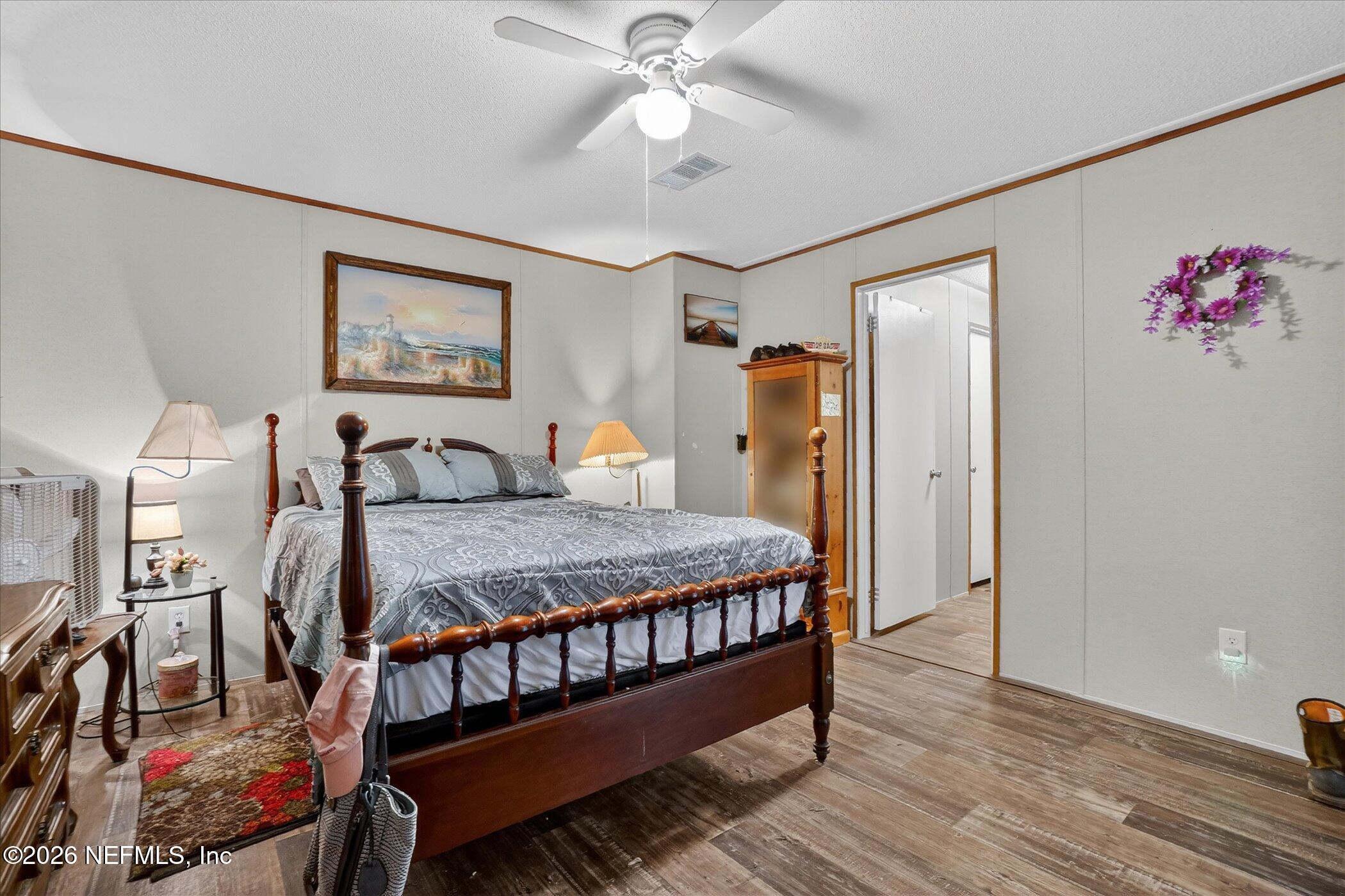 85405 Blackmon Road Yulee, FL 32097 - Photo 18 of 27 a bed room with a bed and a chandelier