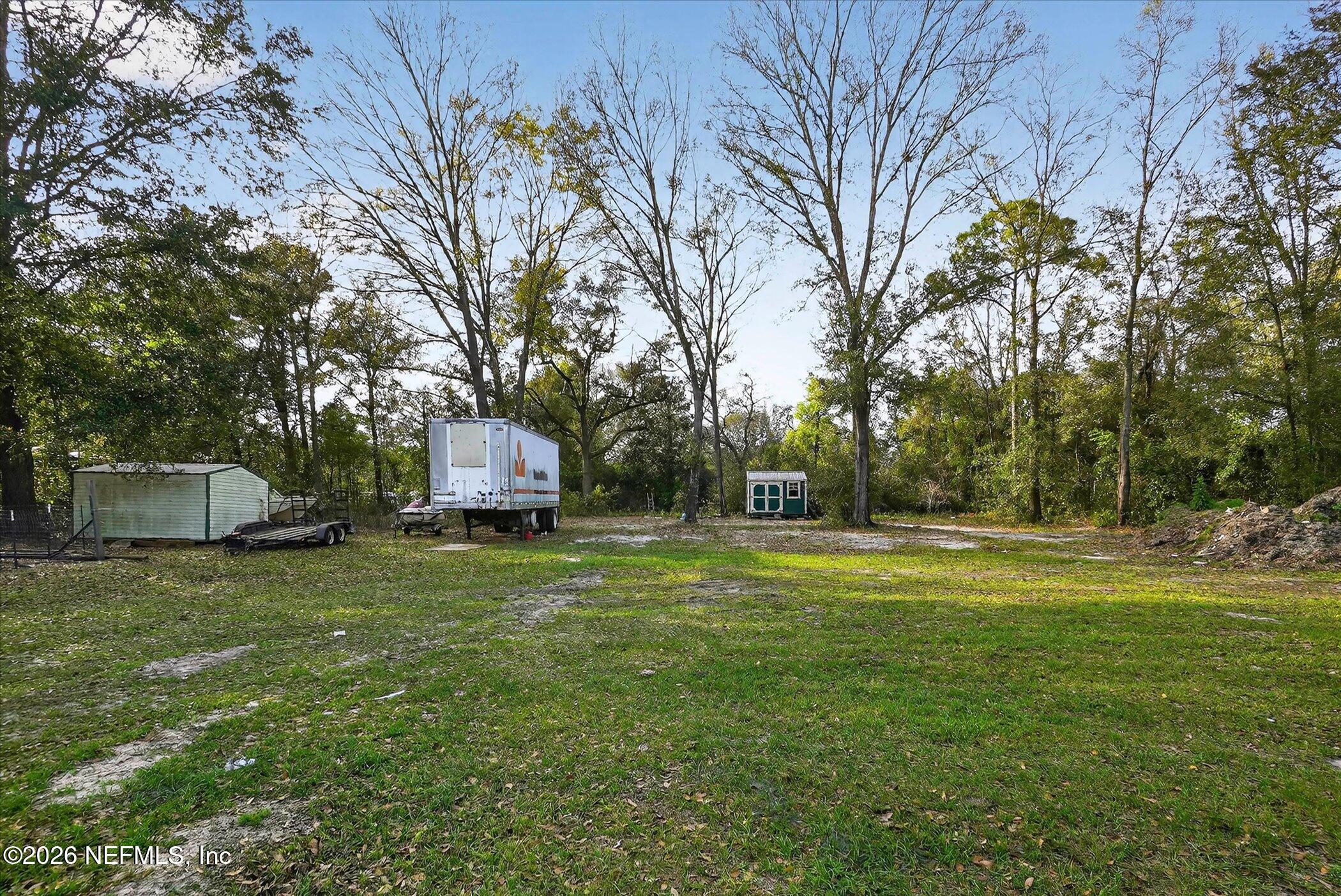 85405 Blackmon Road Yulee, FL 32097 - Photo 25 of 27 a backyard of a house with table and chairs