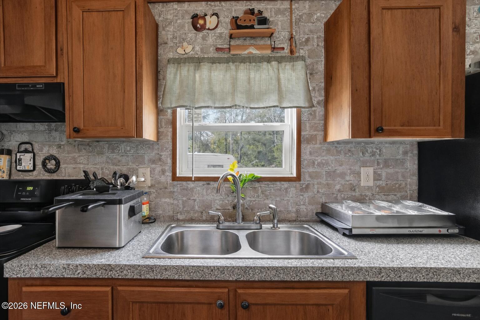 85405 Blackmon Road Yulee, FL 32097 - Photo 6 of 27 a kitchen with granite countertop a sink stove and cabinets