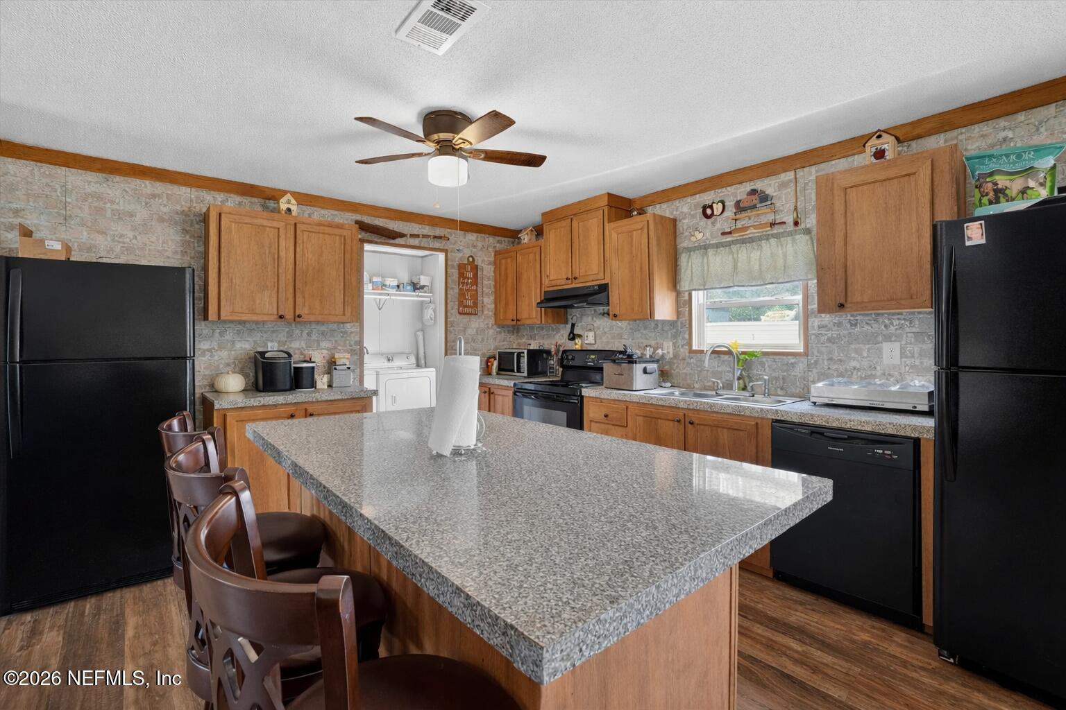 85405 Blackmon Road Yulee, FL 32097 - Photo 7 of 27 a kitchen with granite countertop kitchen island a counter space and stainless steel appliances