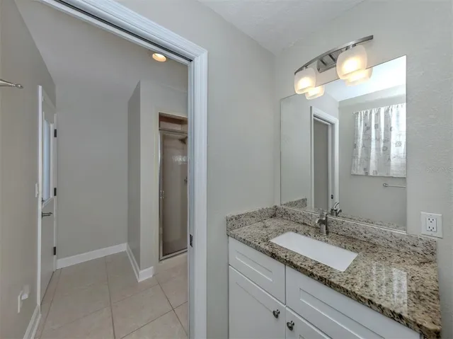a bathroom with a granite countertop sink and a mirror