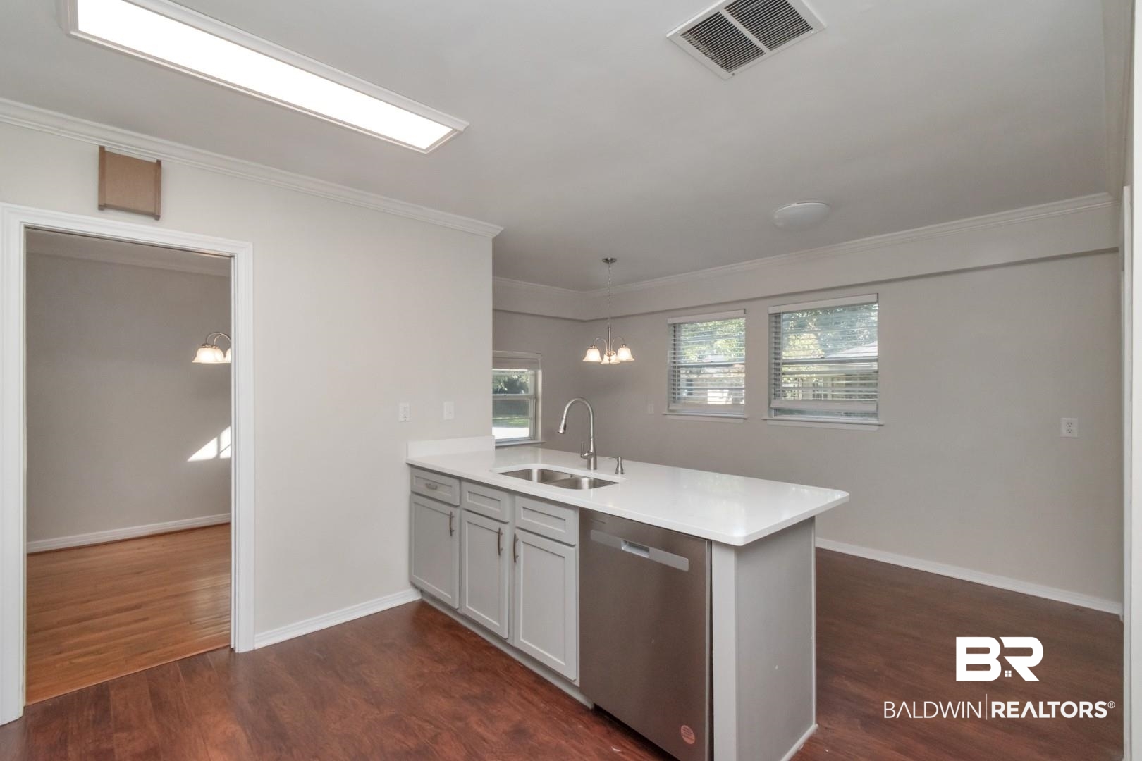 2105 Upham Court Mobile, AL 36607 - Photo 13 of 32 Kitchen featuring pendant lighting, a peninsula, dishwasher, dark wood-style floors, and light stone countertops