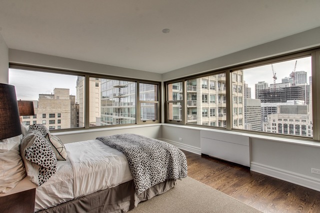 247 East Chestnut Street, Unit 2503 Chicago, IL 60611 - Photo 11 of 24 a spacious bedroom with a large bed and a large window
