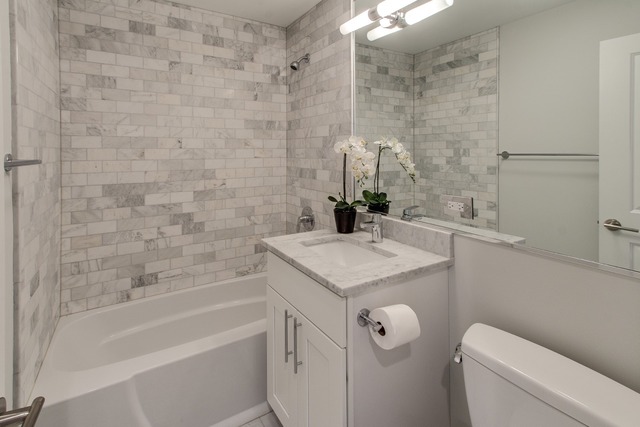 247 East Chestnut Street, Unit 2503 Chicago, IL 60611 - Photo 14 of 24 a bathroom with a granite countertop bathtub sink vanity and toilet