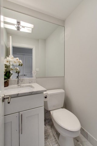 247 East Chestnut Street, Unit 2503 Chicago, IL 60611 - Photo 17 of 24 a bathroom with a granite countertop toilet a sink and a mirror
