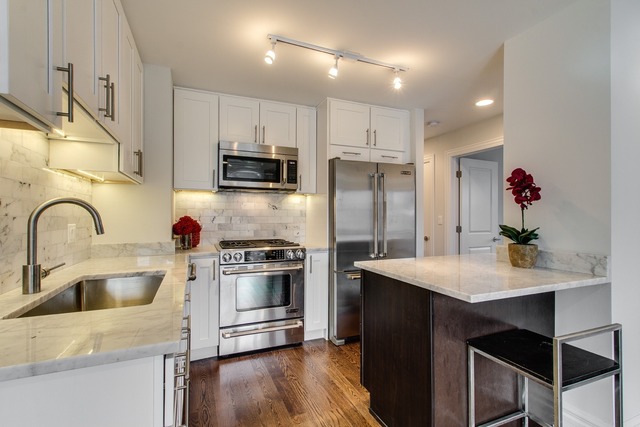 247 East Chestnut Street, Unit 2503 Chicago, IL 60611 - Photo 9 of 24 a kitchen with kitchen island a sink appliances and cabinets