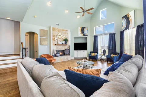 a living room with furniture kitchen view and a large window
