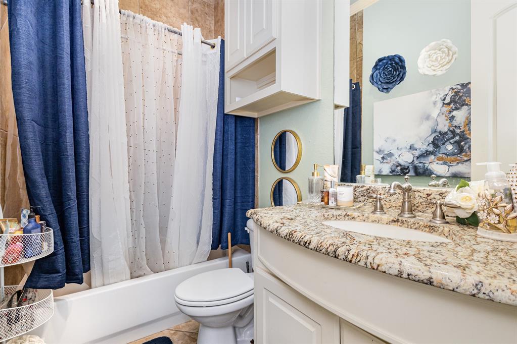 123 Ranch House Road Rockwall, TX 75032 - Photo 17 of 23 a bathroom with a granite countertop sink vanity mirror toilet and shower