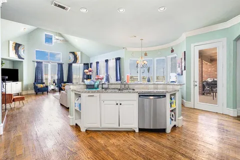 a kitchen with stainless steel appliances kitchen island granite countertop a refrigerator a stove and a sink
