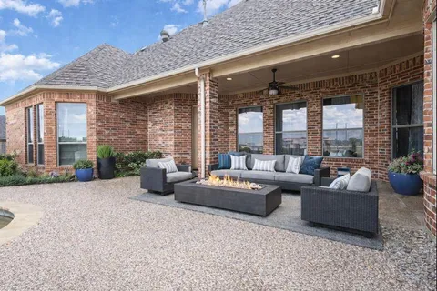 a living room with patio furniture and a potted plant