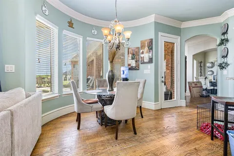 a dining room with furniture a chandelier and wooden floor