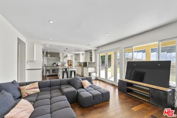 a large kitchen with kitchen island a large counter top space a sink stainless steel appliances and cabinets