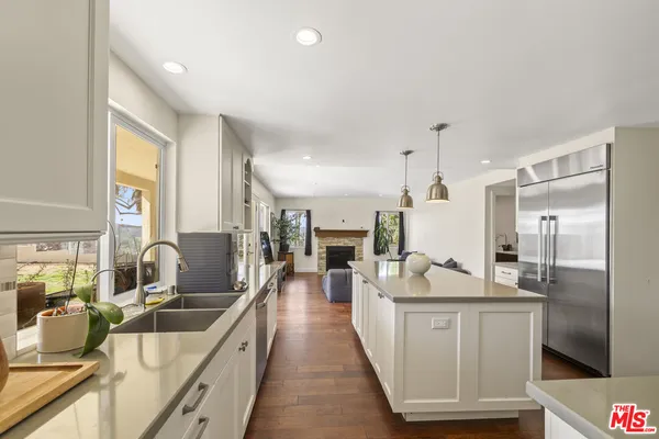 a kitchen with stainless steel appliances granite countertop a sink a stove and a refrigerator