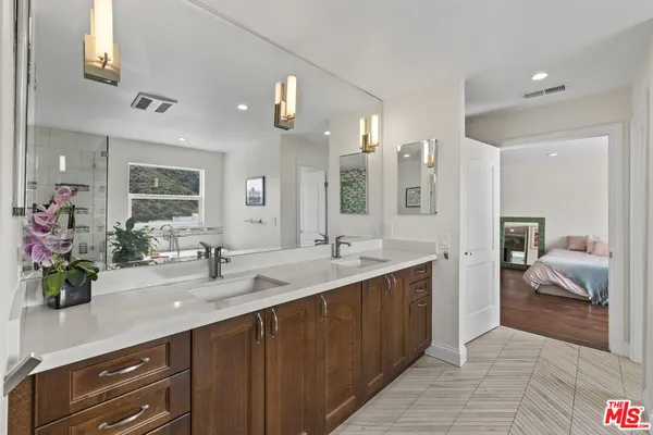 a spacious bathroom with a double vanity sink a mirror and a bathtub