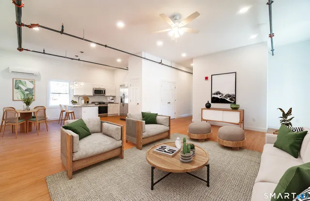 a living room with furniture kitchen view and a chandelier