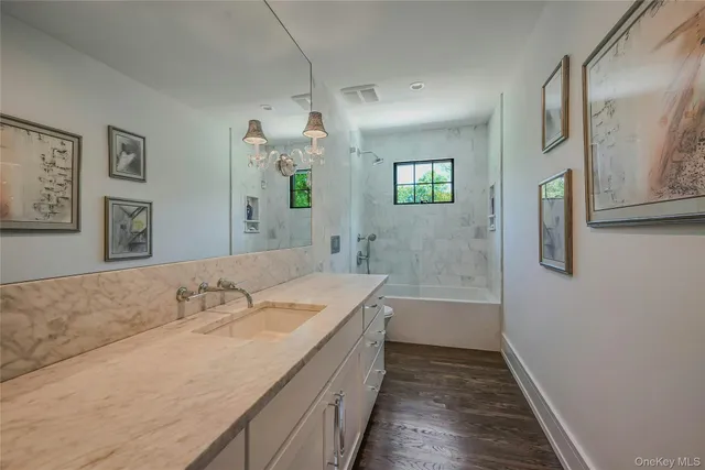 a bathroom with a tub a sink and mirror