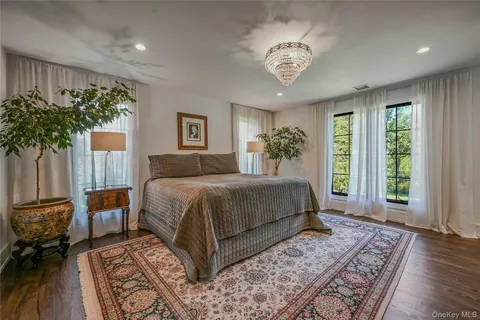 a bedroom with a large bed and a chandelier