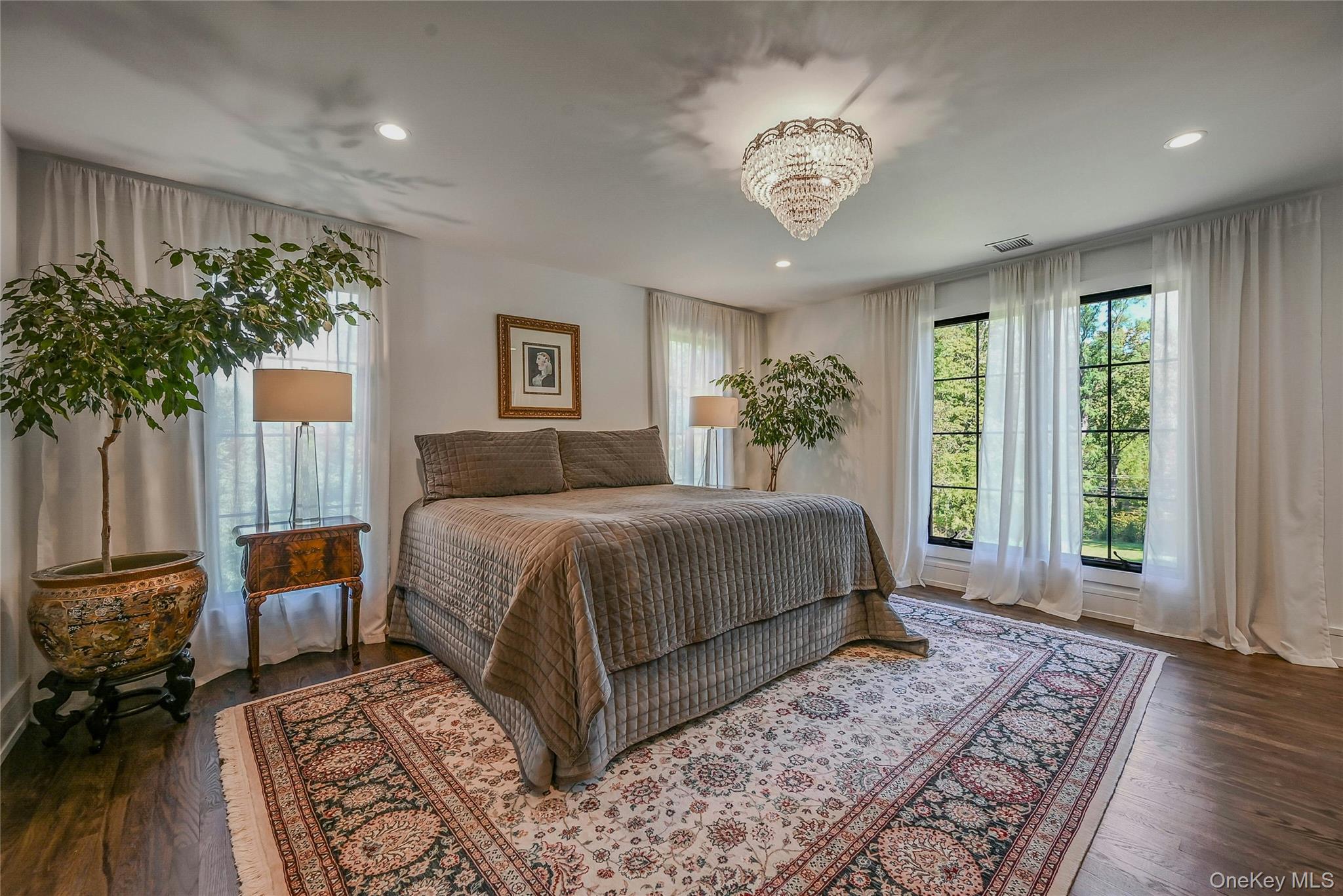 262 Huntington Bay Road Huntington Bay, NY 11743 - Photo 12 of 39 a bedroom with a large bed and a chandelier