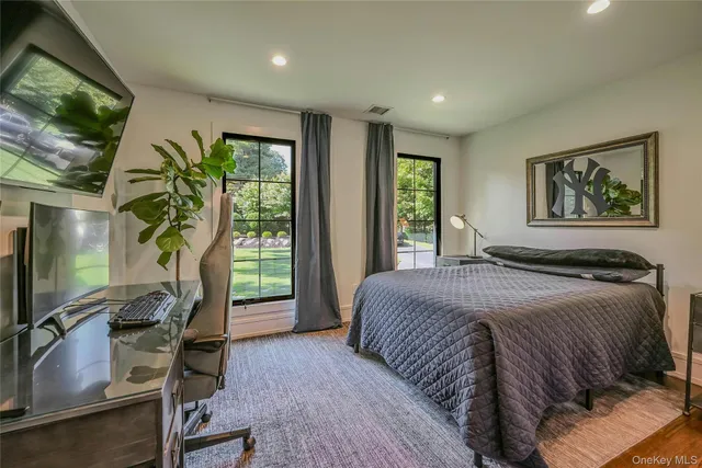 a bedroom with a bed and a flat tv screen on dresser