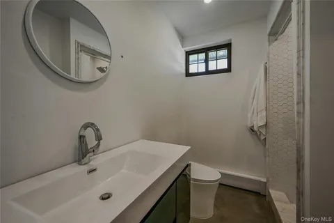 a bathroom with a sink a toilet and a mirror