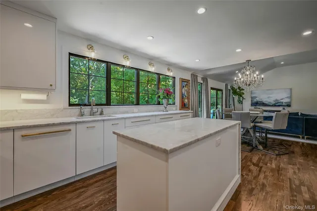 a kitchen with kitchen island a large counter top space appliances and a center island
