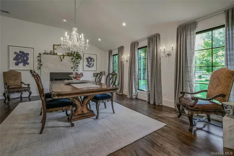 a view of a dining room with furniture a chandelier and wooden floor