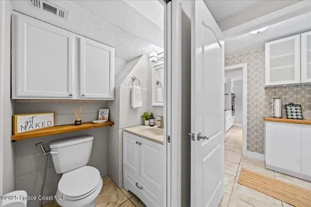 a view of bathroom with a toilet sink and mirror