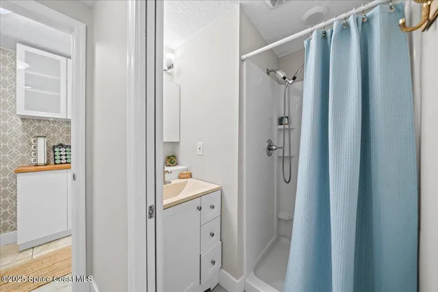 a bathroom with a shower and a sink