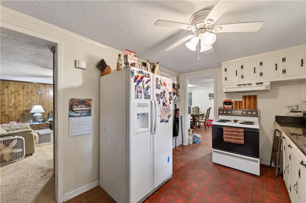4399 Highway 411 Rydal, GA 30171 - Photo 3 of 37 a kitchen with stainless steel appliances granite countertop a refrigerator a stove a sink dishwasher a dining table and chairs with wooden floor