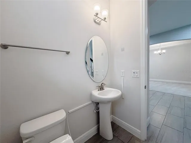 a bathroom with a granite countertop sink toilet and mirror
