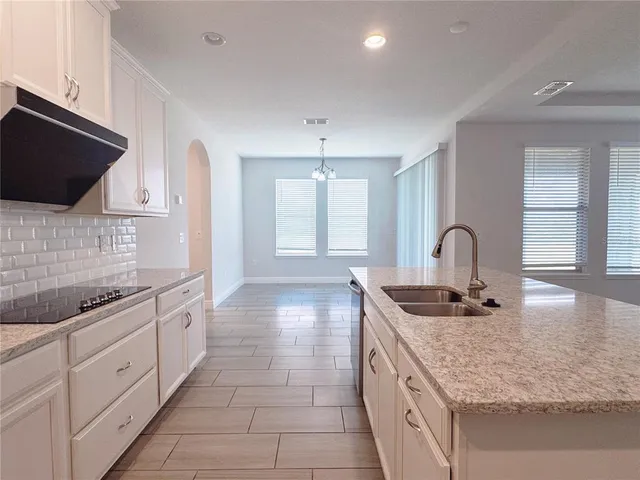 a bathroom with a granite countertop sink and a window