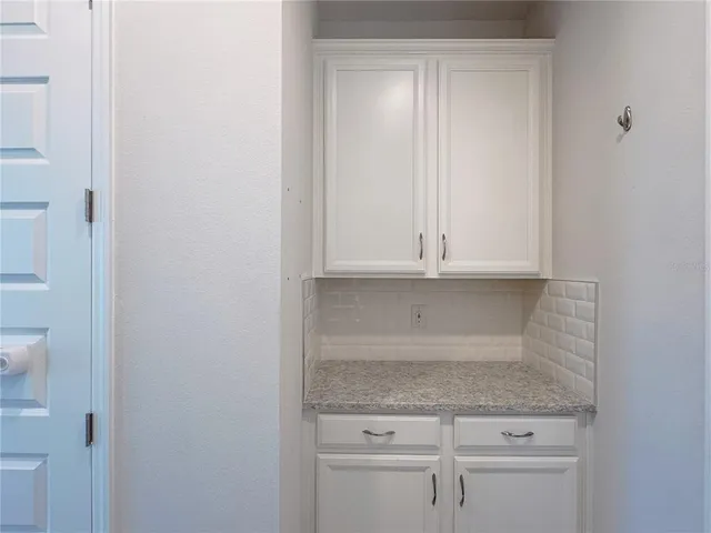 a bathroom with a granite countertop sink a mirror and a bathtub