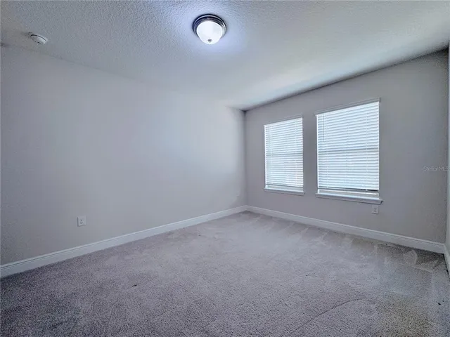 a view of a patio with a table and chairs under an umbrella