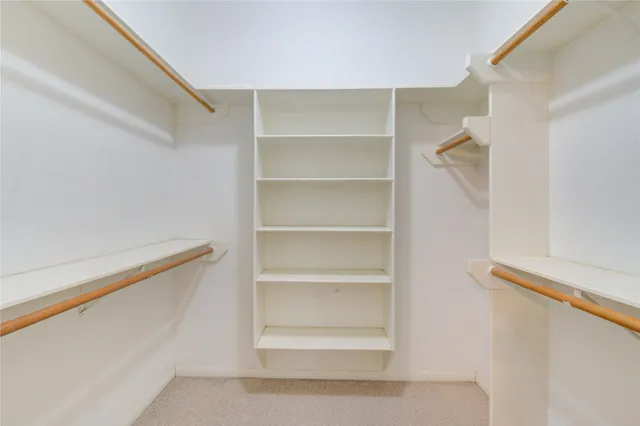 a view of walk in closet with empty racks