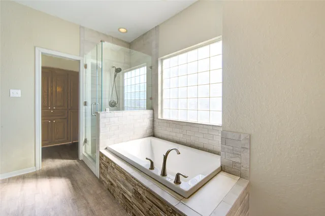 a bathroom with a tub a sink and a window