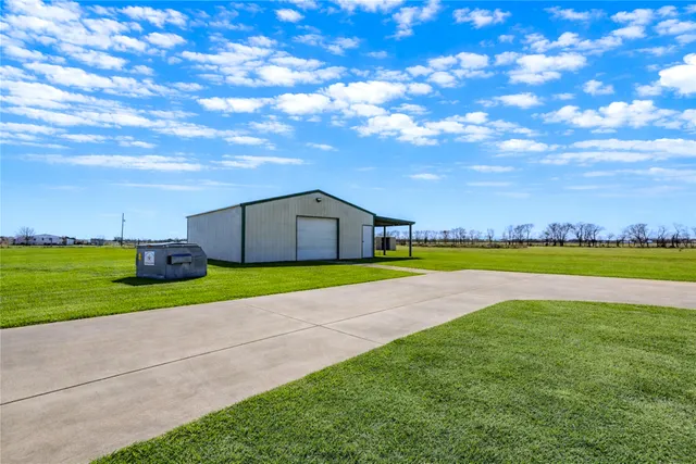a view of a big house with a big yard and large trees